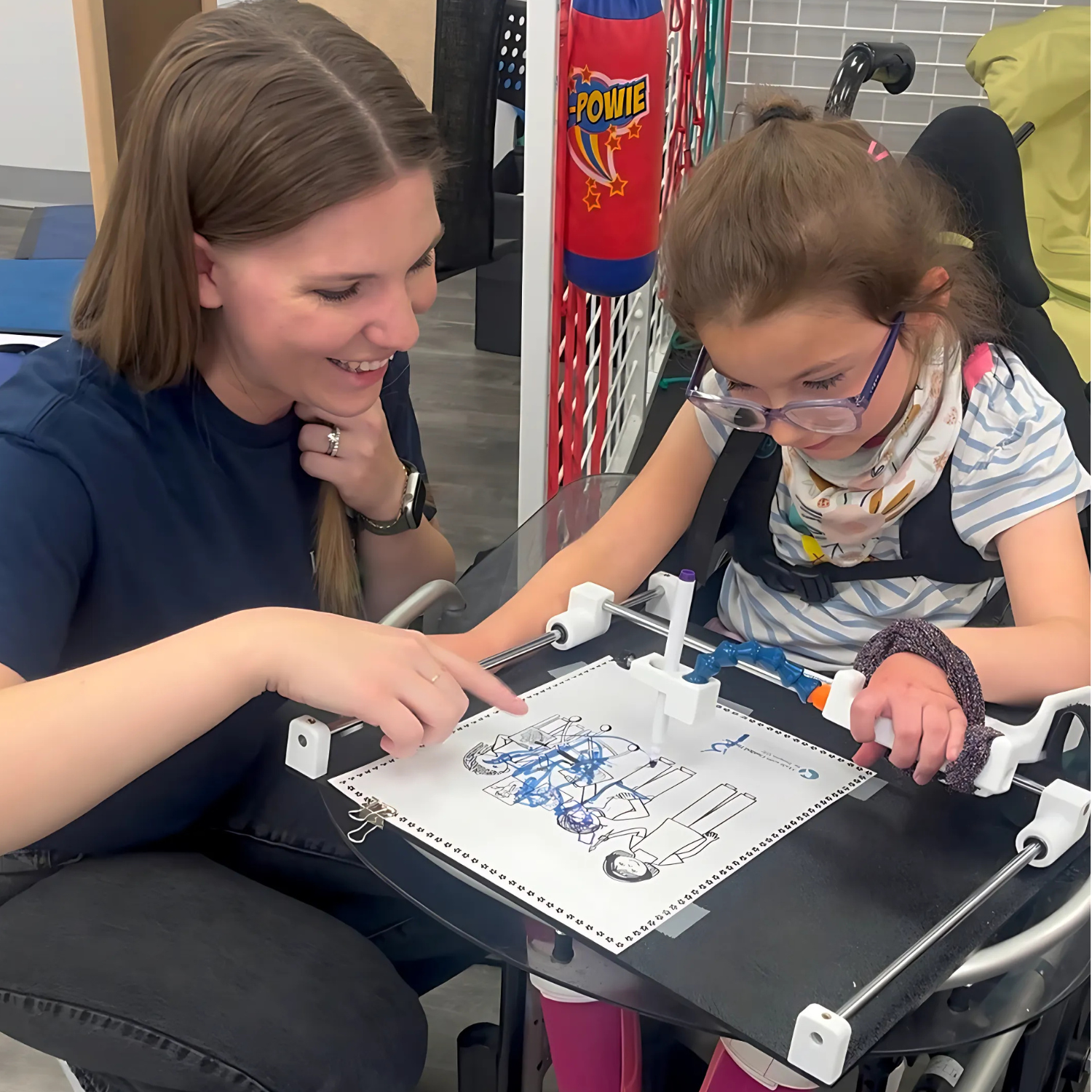 Child using Guided Hands to colour in picture.