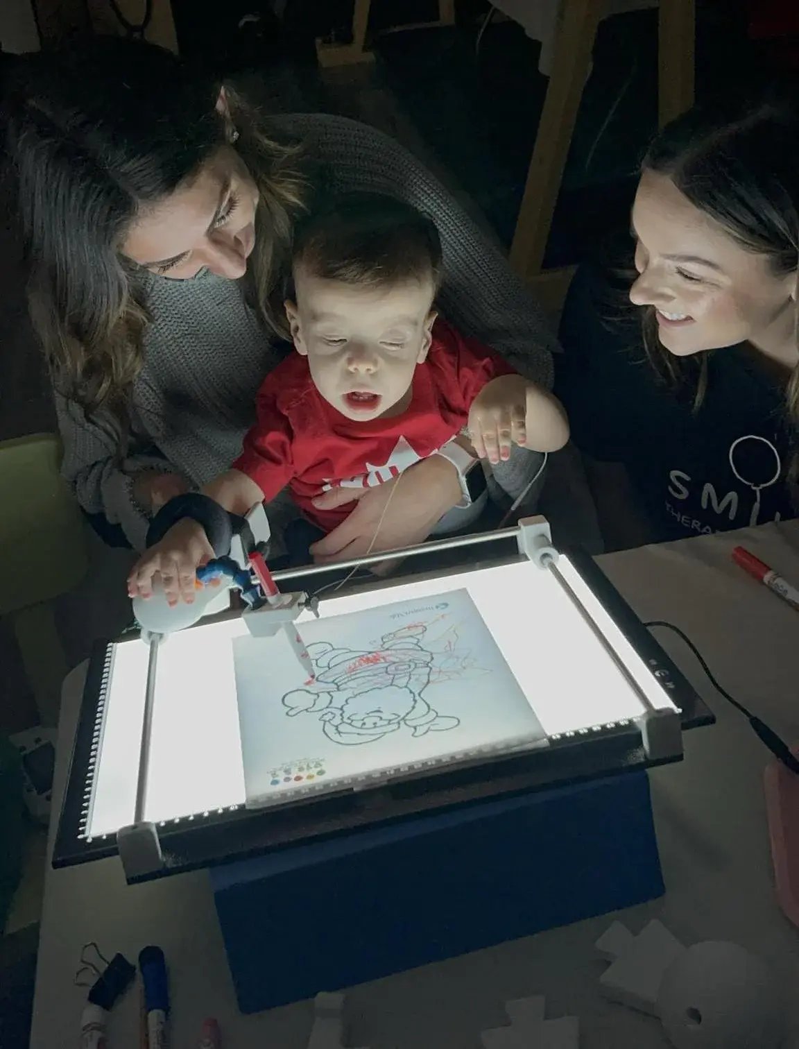 Child using Guided Hands with light board.