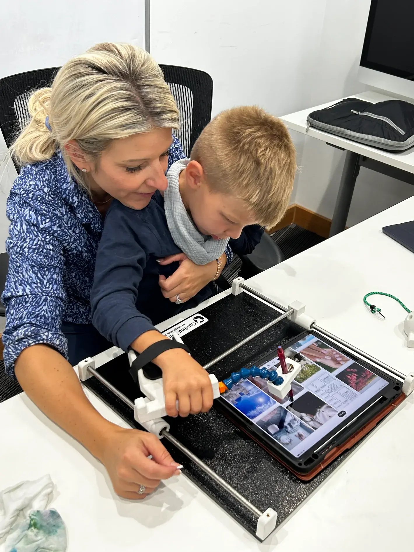Mother and child using Guided Hands with touch screen device iPad Tablet